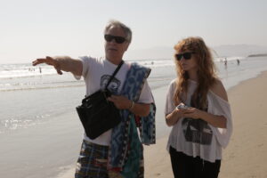 Mark Pirro pointing ahead and directing actress Stef Dawson on Venice Beach for "Rage of Innocence."