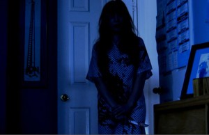 Raven Sutton looking sinister as she approaches her enemy in a dark room in "Rage of Innocence."