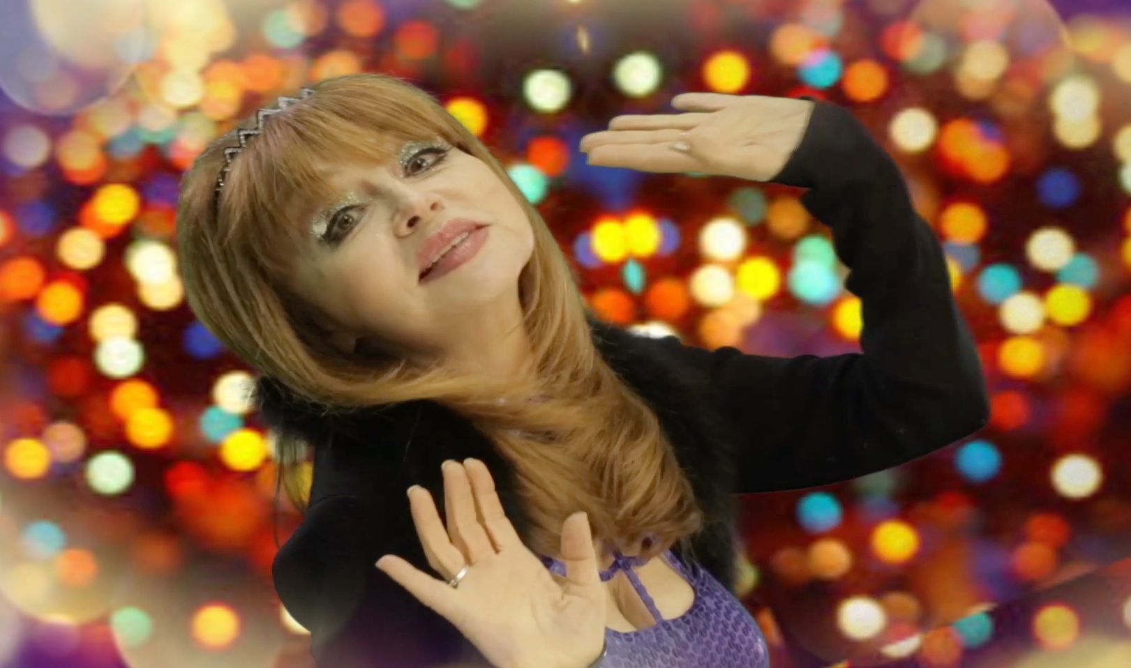 Comedian Judy Tenuta with sparkling lights behind her